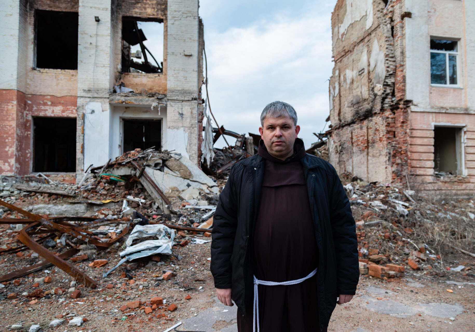 Priest Peter stands near the house destroyed by Russian troops in the city of Zhytomyr. In March 2022, the city of Zhytomyr suffered missile and air strikes from the Russian military.